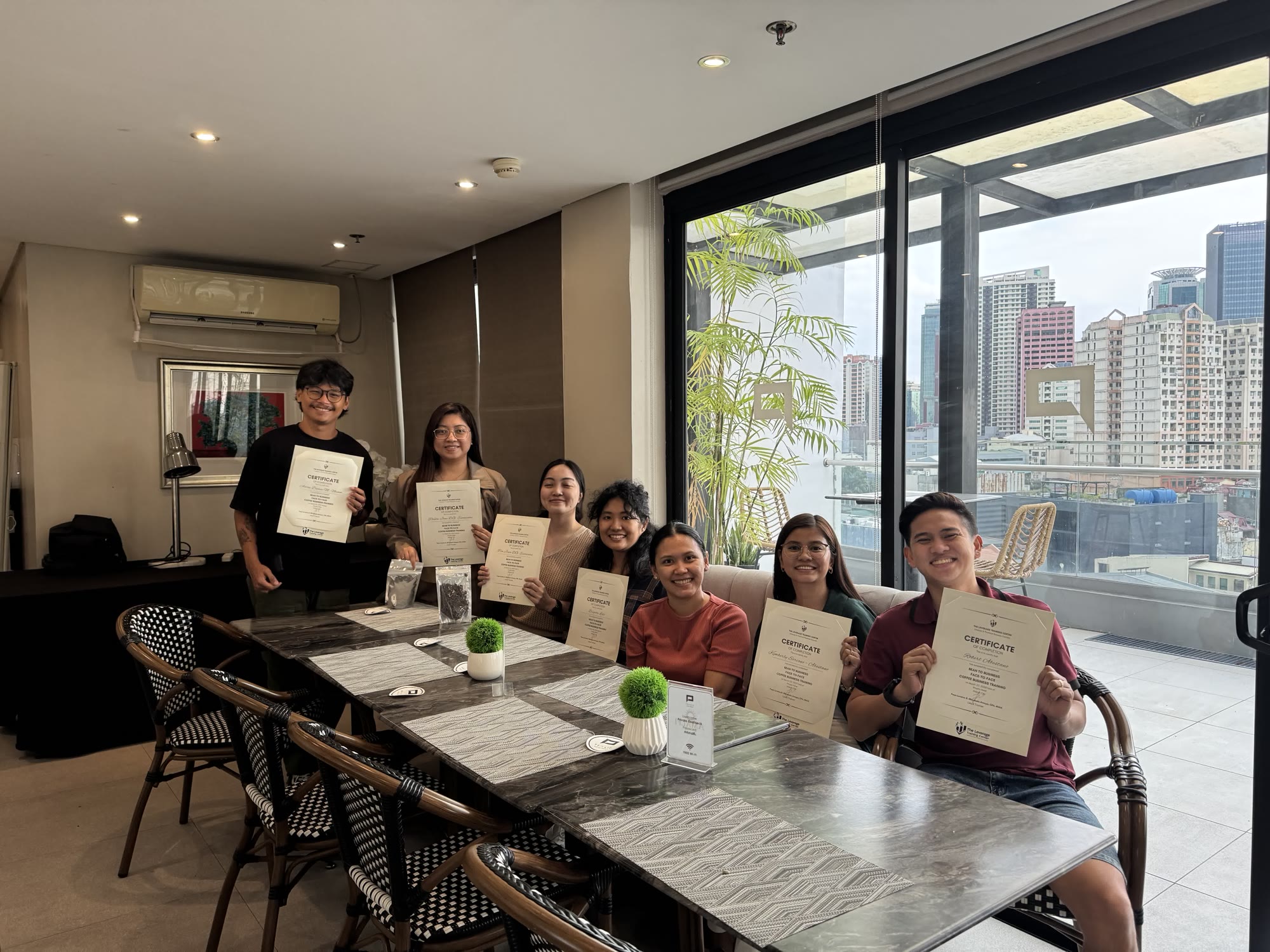 Graduates holding their certificates at the end of a face-to-face program