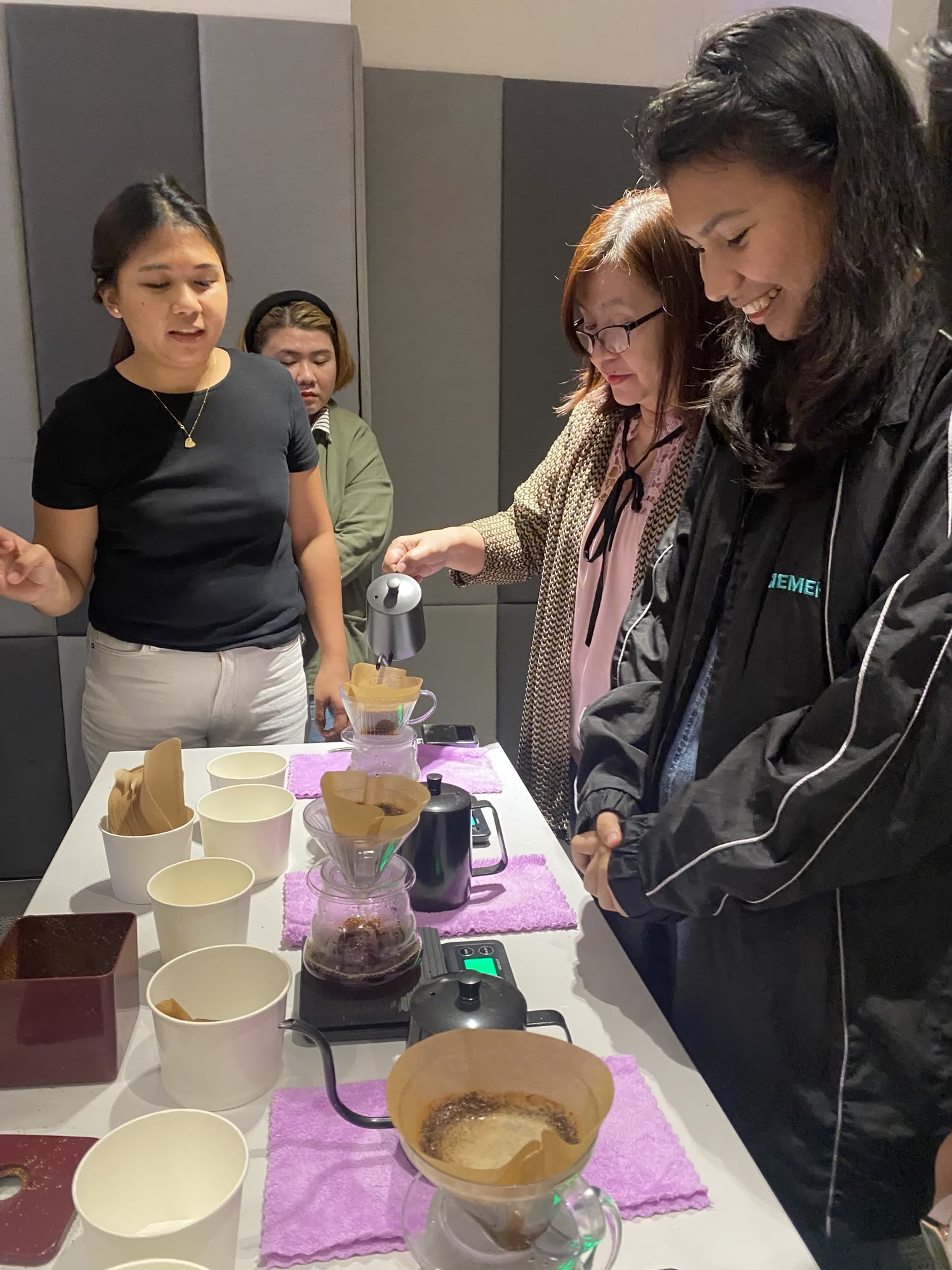 An instructor guiding a participant through a pourover pour